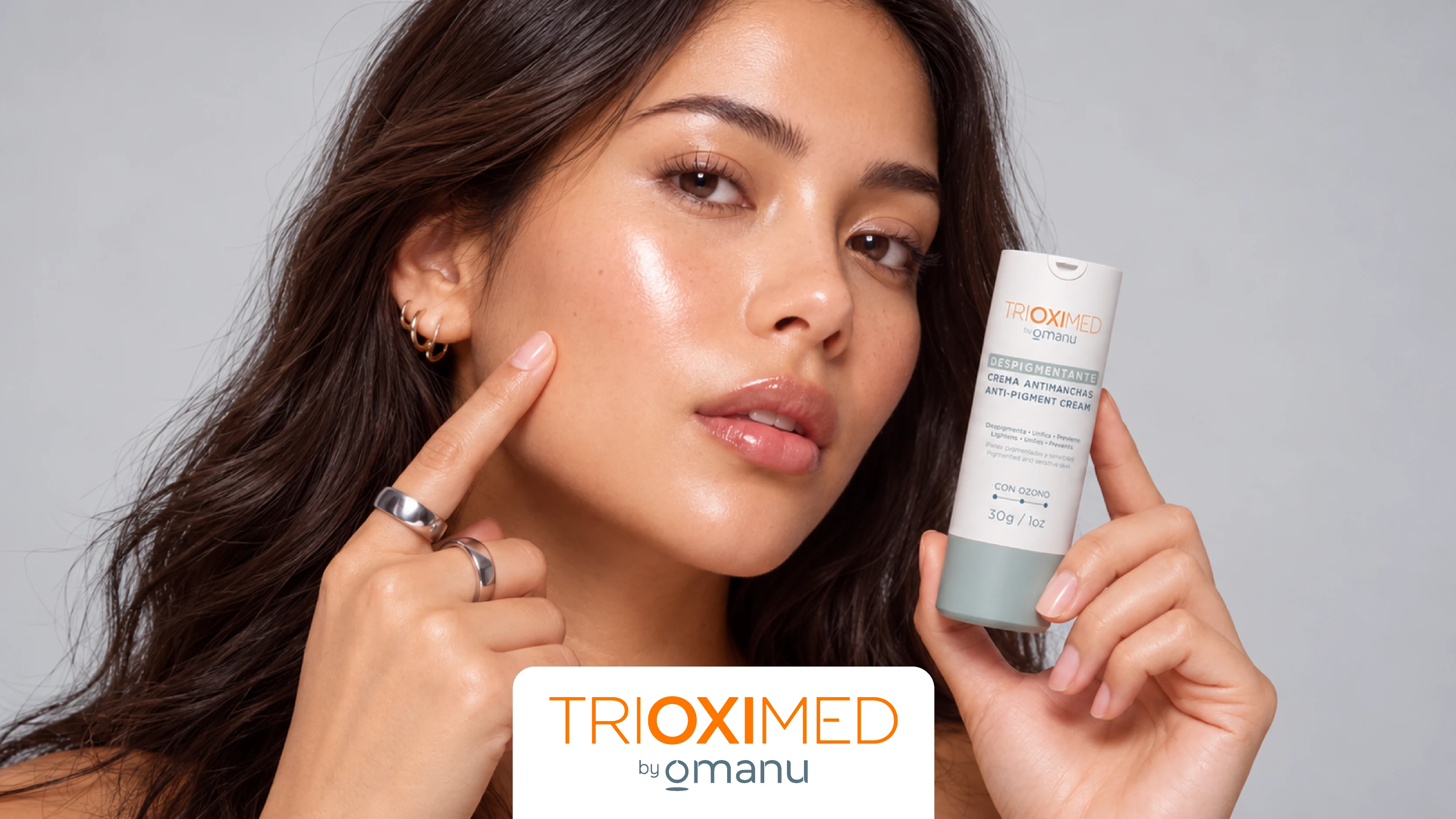 Mujer mostrando la crema despigmentante Trioximed Antimanchas 30 g junto a su rostro, para el cuidado de manchas e hiperpigmentación facial.